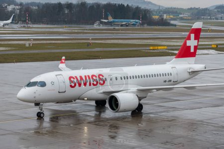 Foto de Zurich, Suiza, 17 de enero de 2024 HB-JBB Swiss international airlines Bombardier CS-100 aircraft is taxiing to the gate during a rain shower - Imagen libre de derechos