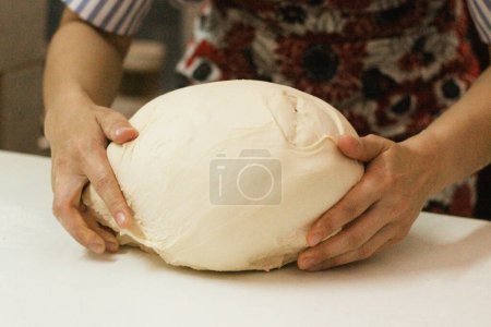 Close up of woman kneading dough, Hands forming bread in an organic bakeryHands forming bread in local bread store