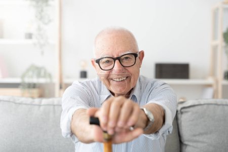 Porträt eines glücklichen, positiven alten Mannes, der lächelt und in die Kamera blickt