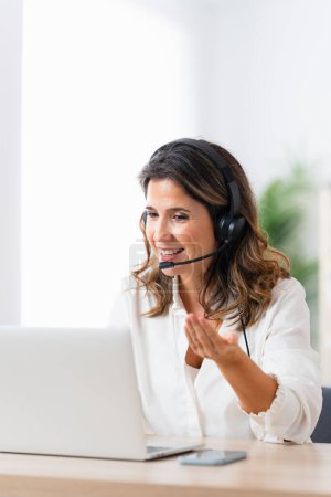 Vertical photo with copy space of a mature woman working in a domestic call center