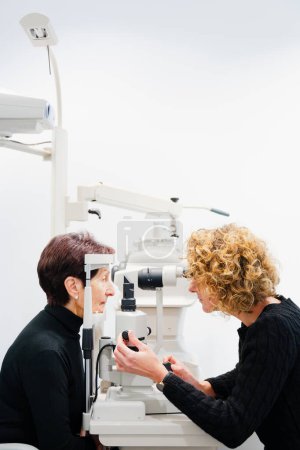 Ophtalmologist using modern biomicroscopy machine with patient.
