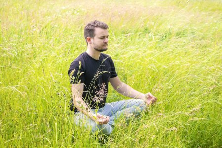 Téléchargez les photos : Méditation dans la nature. Un homme médite dehors. pose humaine pour la méditation - en image libre de droit