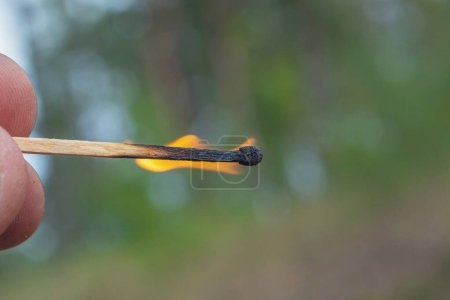 Photo for Hold a burning match. Fire from a match. Fire hazard - Royalty Free Image