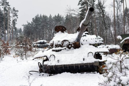 Russian battle tank in the snow which was destroyed on the roadside of highway during hostilities in Russian invasion of Ukraine, 2022. War in Ukraine in winter.