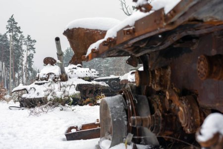Russian battle tank in the snow which was destroyed on the roadside of highway during hostilities in Russian invasion of Ukraine, 2022. War in Ukraine in winter.