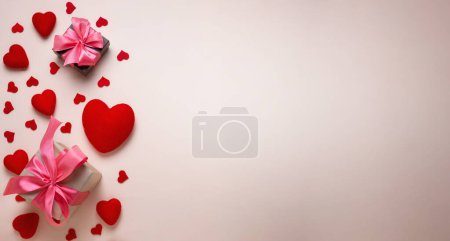 Téléchargez les photos : Valentine's day background. Pastel banner with red hearts and gift with ribbon. Place for text. - en image libre de droit