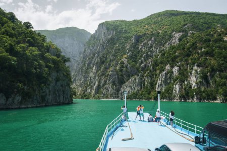 View from the ferry on Lake Komani. A tourist boat overtakes the car ferry on Komani Lake in the dinaric alps of Albania