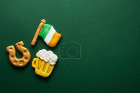 Téléchargez les photos : Banner for St. Patrick's Day on green background. Coins, horseshoes, Ireland flag as symbols of the holiday. Place for text. Gingerbread cookie items. - en image libre de droit