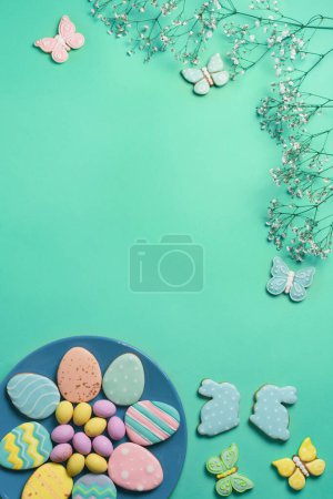 Téléchargez les photos : Bannière de Pâques sur fond de menthe. Biscuits maison au pain d'épice sur une assiette bleue, œufs de Pâques et biscuits en forme de lapin et de papillon. Concept de Pâques. - en image libre de droit