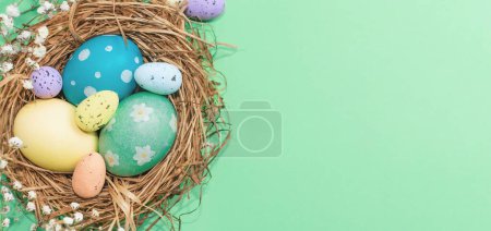 Téléchargez les photos : Bannière de Pâques sur fond vert. Nid d'oiseau avec œufs de Pâques. Joyeuses Pâques. - en image libre de droit