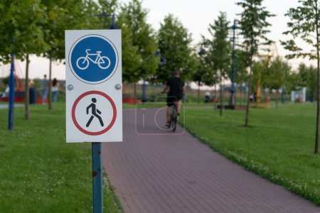 Téléchargez les photos : Panneau de signalisation interdisant les piétons, cyclistes autorisés. Le symbole de la voie cyclable indiquait la route pour les vélos sur la passerelle piétonne. - en image libre de droit