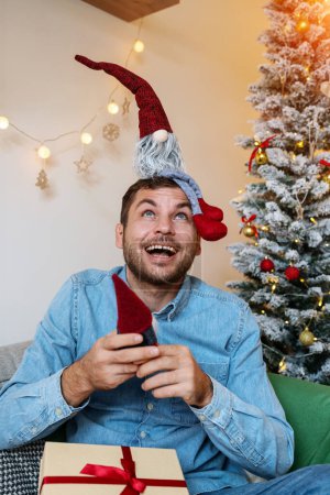 Foto de Hombre adulto feliz jugando con gnomos de juguete de Navidad. Infancia e infantilismo de un adulto. - Imagen libre de derechos