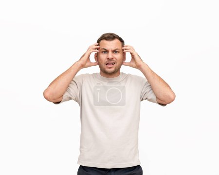 Nonplussed adult man expressing emotions of confusion on white background in studio.