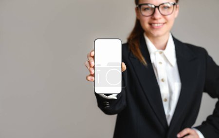 Mockup pantalla en blanco del teléfono inteligente en la mano de la mujer de negocios. Empresaria mostrando la pantalla de su teléfono móvil.