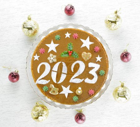 2023 New Year's cake and gold and  red christmas baubles