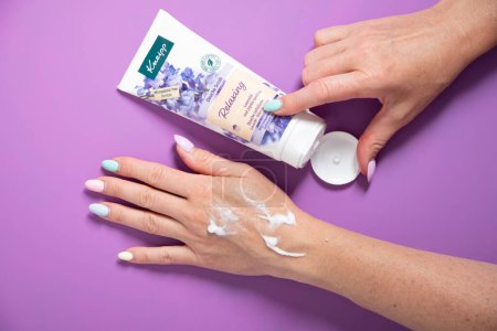 Photo for Woman applies a jar of cleansing skin scrub to her hand,cosmetics daily rituals, exfoliante Kneipp cosmetics, Lavender and jojoba,woman testing shower scrub on handAs,Belgium, June 30,2022 - Royalty Free Image