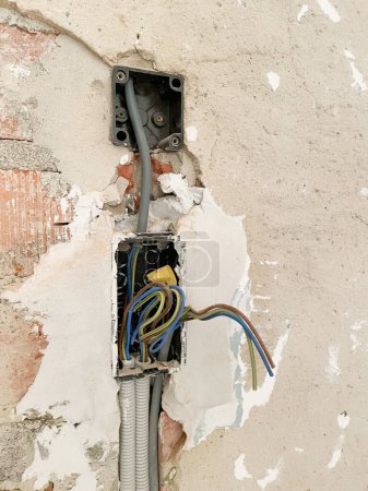 Foto de Zócalos eléctricos rotos en la pared, primer plano, reparación de cableado eléctrico interior, sistema de fijación. Foto de alta calidad. Foto de alta calidad - Imagen libre de derechos