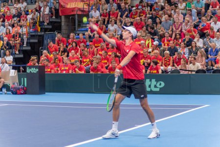 Photo for Davis Cup competition between the countries of Belgium and Uzbekistan at the scoreboard of Sports Hall Alverberg, Joran Vliegen serves the ball: Hasselt, Belgium,September 17, 2023 - Royalty Free Image