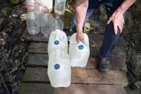 Una fuente subterránea de agua dulce limpia, recipientes llenos para un suministro doméstico de productos esenciales, foto de alta calidad