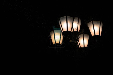 Photo for Old, stylish street lamps at night. A streak of light with illuminated flakes of falling snow - Royalty Free Image