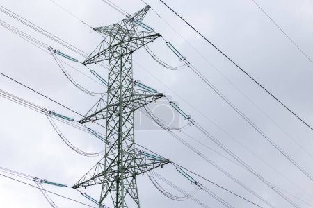 Foto de The silhouette of a high-voltage pylon against a completely cloudy sky. Development of high-voltage transmission networks - Imagen libre de derechos