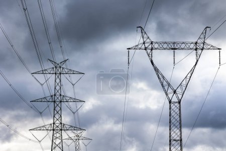 Photo for The silhouette of a high-voltage pylon against a dramatically cloudy sky. Development of high-voltage transmission networks - Royalty Free Image