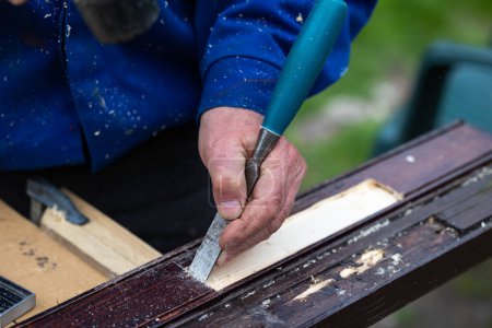 Photo for Hands of a man processing wooden elements with a chisel. Professional hand craft work and do it yourself - Royalty Free Image
