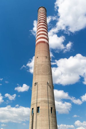 Foto de Una antena de teléfono móvil instalada en una chimenea de una planta de energía alta. Objeto contra el cielo azul en un día soleado. - Imagen libre de derechos