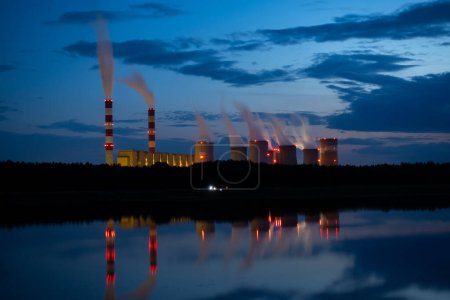 Foto de Vista nocturna de una central eléctrica de carbón. Las luces de la central eléctrica se reflejan en el lago. Altos costos de electricidad. Foto tomada por la noche con luz natural - Imagen libre de derechos