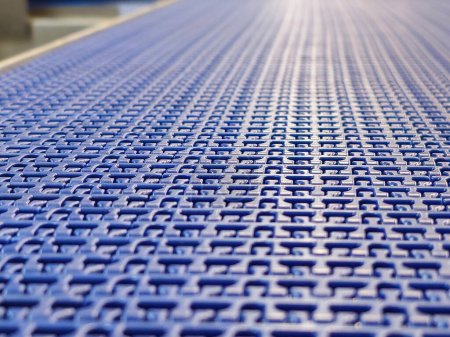 A close-up of a blue polyurethane belt in modular industrial conveyor system. Transport systems in industrial factories.