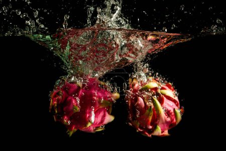 Photo for Dragon Fruit Falling into the water. Splash Drops, Bubbles and Clear Background - Royalty Free Image