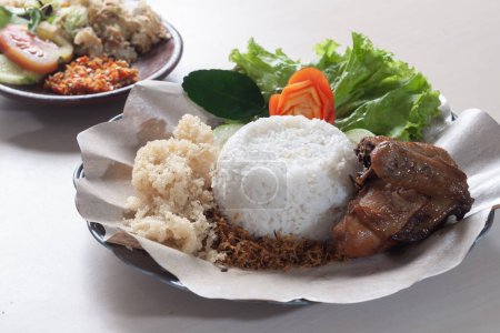 Ayam Goreng Kremes or Crunchy fried chicken served with white rice and spicy chili vegetables