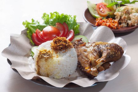 Lalapan Ayam Penyet or Vegetable smashed chicken served with white rice and spicy chili vegetables
