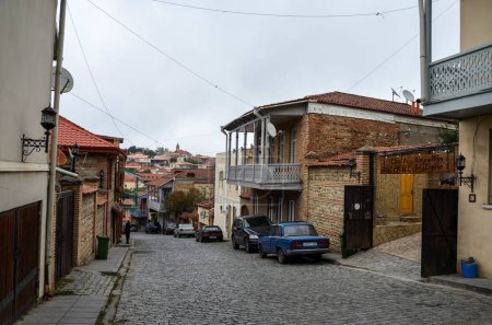 Téléchargez les photos : Rue pavée tortueuse avec maisons colorées, toits en tuiles rouges, balcons en bois avec balustrades à Sighnaghi, Géorgie - en image libre de droit