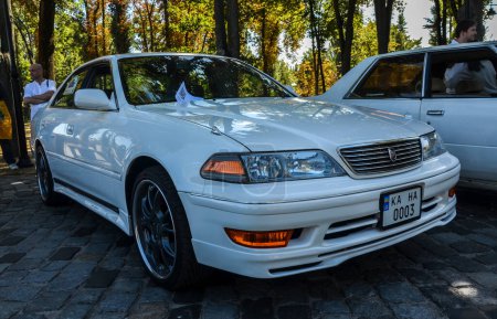 Photo for Toyota Mark II Grande 1997 is a Japanese mid-size white sedan presented at the auto retro festival - Royalty Free Image