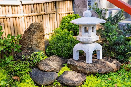 Photo for Ornamental stone lantern with among fresh green plants - Royalty Free Image