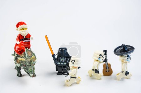 Téléchargez les photos : Bangkok, Thaïlande - Novembre, 18, 2023 : Lego Santa Claus monte un dinosaure pour donner des cadeaux à Lego Star Wars. Concept de célébration de Noël. - en image libre de droit