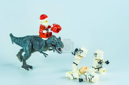 Foto de Bangkok, Tailandia - 18 de noviembre de 2023: Lego Santa Claus monta un dinosaurio para dar regalos a Lego Star Wars. Concepto de celebración de Navidad. - Imagen libre de derechos