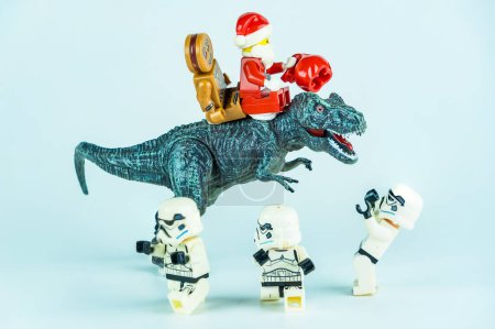 Foto de Bangkok, Tailandia - 18 de noviembre de 2023: Lego Santa Claus monta un dinosaurio para dar regalos a Lego Star Wars. Concepto de celebración de Navidad. - Imagen libre de derechos
