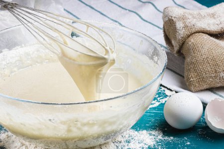Dough for pancakes. Kneading the dough with a whisk. Liquid dough. High quality photo