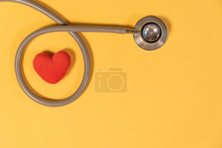 Foto de Estetoscopio de una sola cabeza con corazón rojo sobre fondo amarillo - Imagen libre de derechos