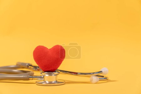 Foto de Estetoscopio de una sola cabeza con corazón rojo sobre fondo amarillo - Imagen libre de derechos