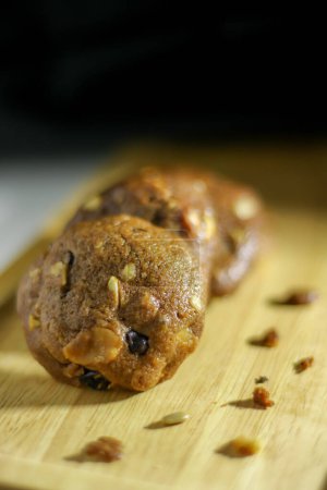 Téléchargez les photos : Biscuits au chocolat sucré faits maison sur table en bois avec fond noir - en image libre de droit