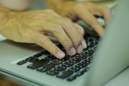 Téléchargez les photos : Les mains de l'homme travaillant sur le clavier de l'ordinateur portable, gros plan. - en image libre de droit