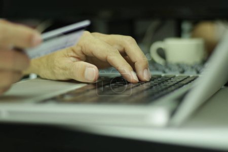 Téléchargez les photos : Main d'homme travaillant avec le clavier lobtop sur les achats en ligne avec carte de crédit. Shopping concept en ligne. - en image libre de droit
