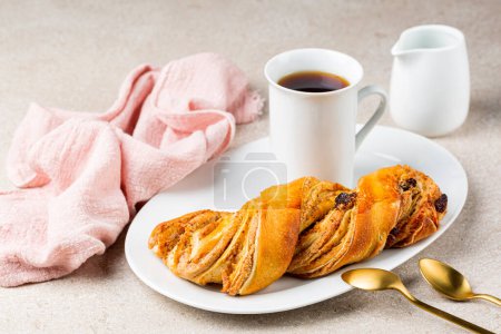 Dessert Kranz with a cup of coffee. A type of venetian and austrian pastry made of two types of dough, the brioche and the puff pastry, interspersed with a filling of raisins and almonds,  closed in a spiral. 