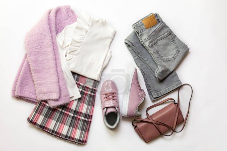 Photo for 8 year old Girl clothes set, white blouse, grey geans and plaid skirt, pink sneakers, small  bag on white background. - Royalty Free Image