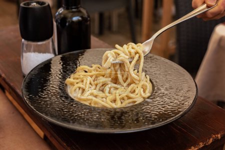 Photo for Italian Roman pasta dish cacio e pepe. Traditional for Lazio and Rome. Tonnarelli or spaghetti with black pepper and Pecorino Romano cheese. - Royalty Free Image