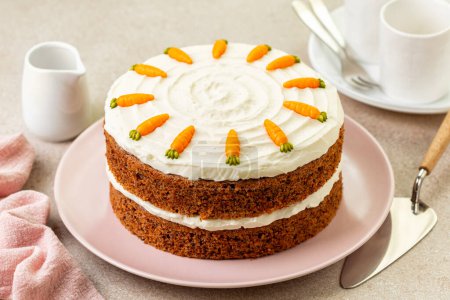Photo for Table with homemade carrot cake made with carrots, walnuts, iced with cream cheese. Chocolate decoration. Sweet dessert. Beige background. - Royalty Free Image