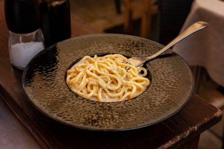 Photo for Italian pasta dish cacio e pepe. Traditional for Lazio and Rome. Tonnarelli or spaghetti with black pepper and Pecorino Romano cheese. - Royalty Free Image